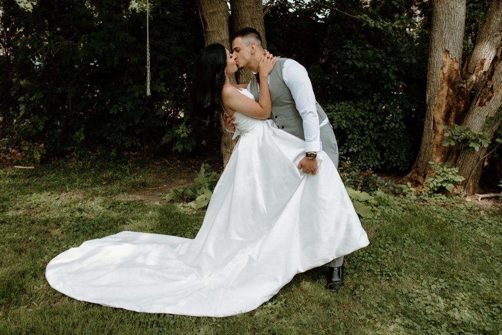 Bride and groom kiss at backyard wedding