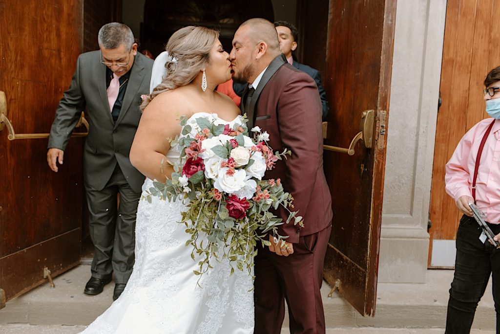 Bride and groom kiss after wedding in front of Chicago church