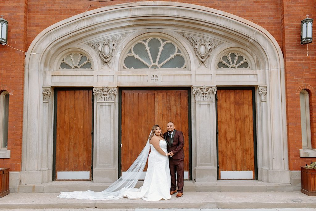 Bride and groom pose after wedding in front Chicago church