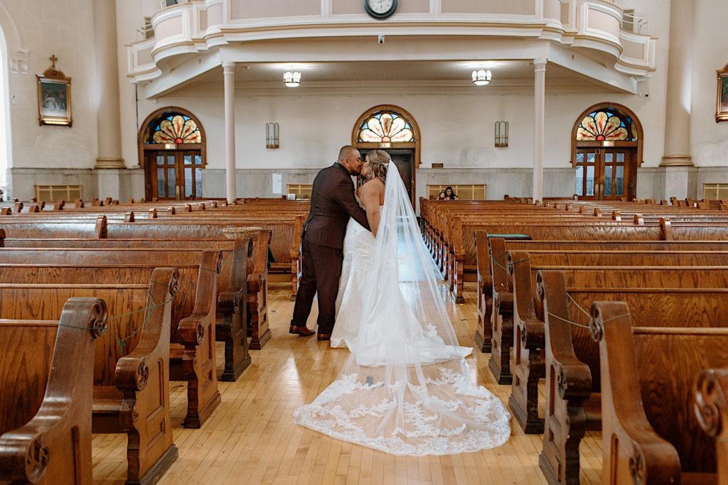 Bride and groom kiss in Lady of Tepeyac church in Chicago